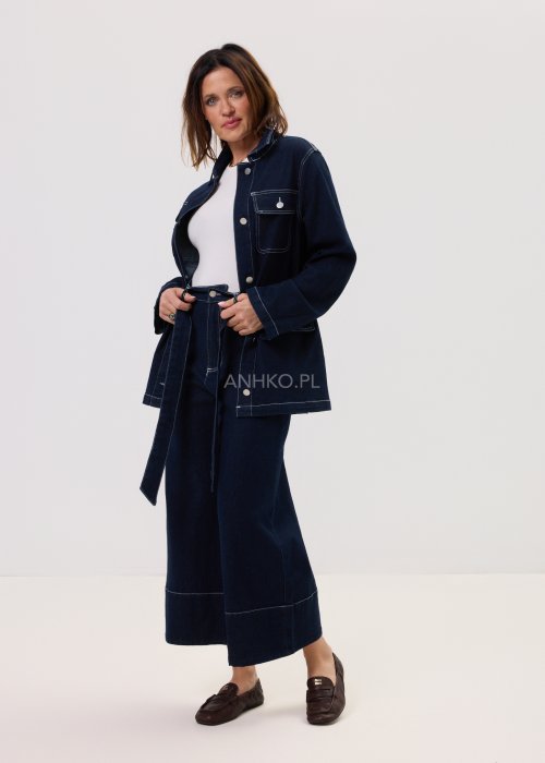 Damska kurtka jeansowa Utility w kolorze dark denim, klasyczny kołnierz, metalowe napy i wyraźne białe szwy, podkreślona wiązaniem w pasie w miejskim wydaniu.