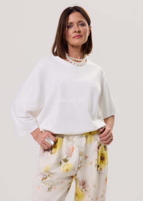 Biała bluzka damska Soft Flow oversize o luźnym kroju z krótkim rękawem, stylizacja ze spodniami.