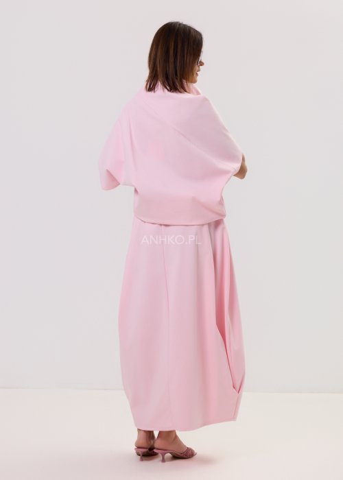 Różowa spódnica maxi o luźnym, nowoczesnym kroju z elastyczną gumką w pasie i miękko układającą się tkaniną, prezentowana na modelce w minimalistycznej stylizacji.