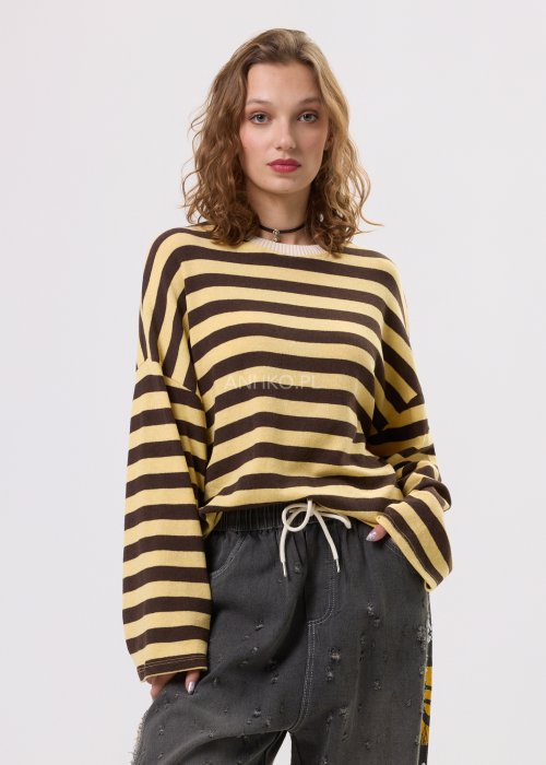 Damski sweter oversize w brązowo-beżowe paski z długim rękawem i okrągłym dekoltem – luźna stylizacja z jeansowymi spodniami.