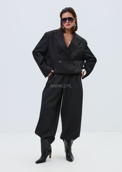 Czarna damska kurtka-marynarka oversize z szerokimi klapami i podwójnym zapięciem na guziki, elegancki model o nowoczesnym kroju w minimalistycznej stylizacji.
