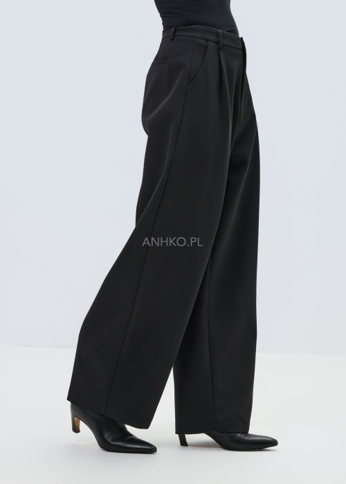 Czarne damskie spodnie garniturowe z szeroką nogawką, elegancki model z wysokim stanem i zakładkami z przodu w minimalistycznej stylizacji.