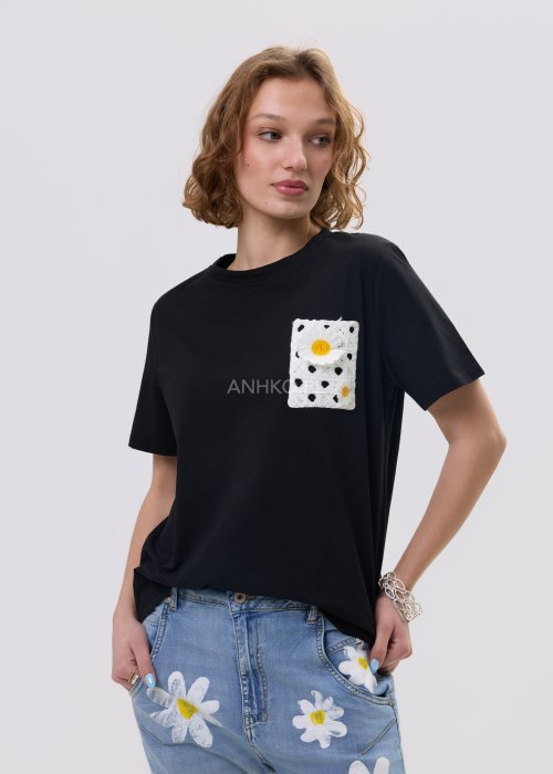 Czarna bluzka t-shirt damski z krótkim rękawem i ozdobną kieszonką z ażurową aplikacją w kształcie stokrotki.
