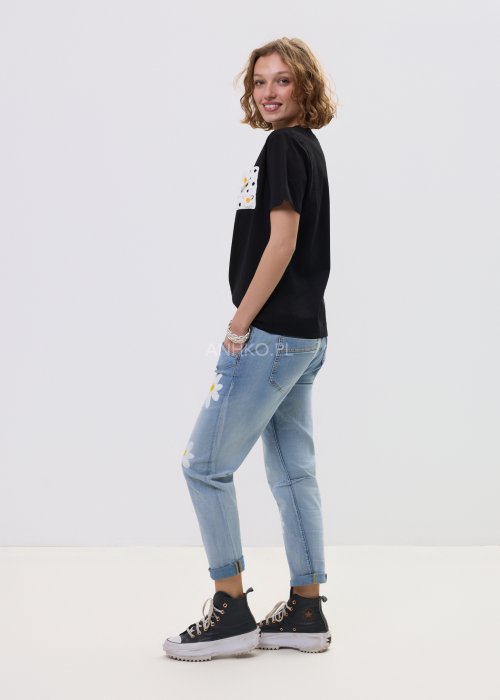Czarna bluzka t-shirt damski z krótkim rękawem i ozdobną kieszonką z ażurową aplikacją w kształcie stokrotki.