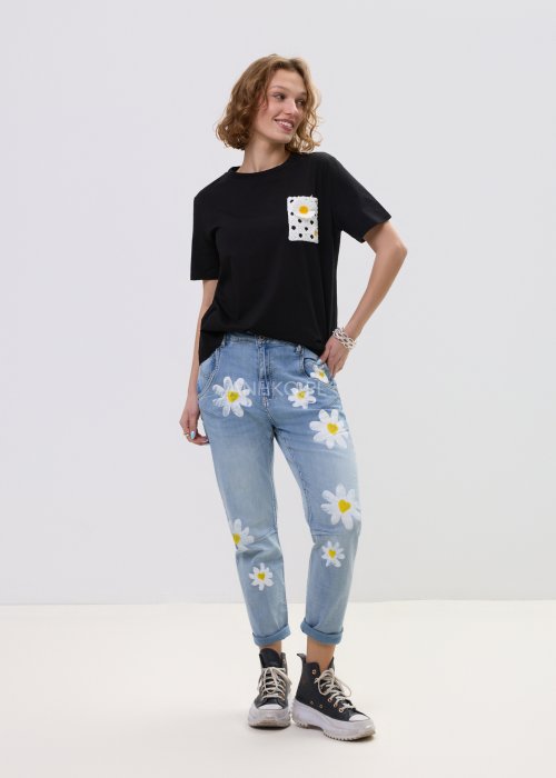 Czarna bluzka t-shirt damski z krótkim rękawem i ozdobną kieszonką z ażurową aplikacją w kształcie stokrotki.