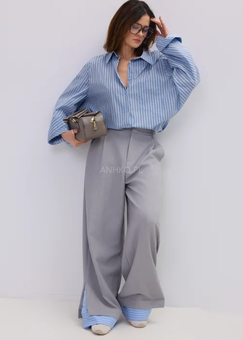 Szerokie spodnie damskie typu wide leg w kolorze szarym z wysokim stanem, elegancki fason – stylizacja ze sneakersami i koszulą.