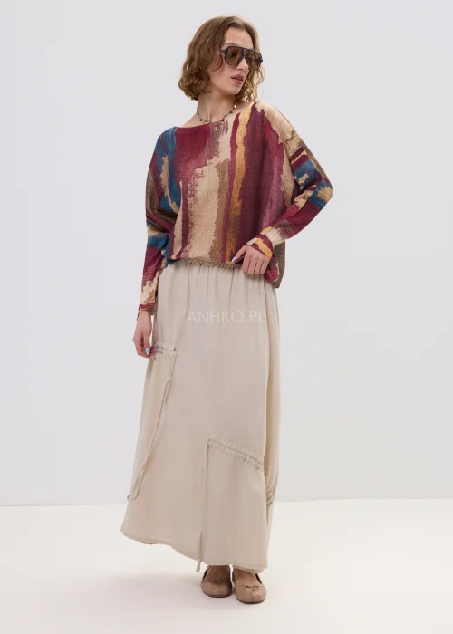 Sweter oversize w wielokolorowy, artystyczny print – odcienie bordo, beżu i niebieskiego, luźny fason, stylizacja z jasną spódnicą.