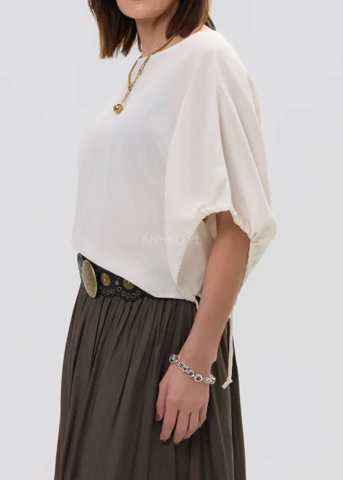 Bluzka damska o luźnym, oversize’owym kroju w odcieniu ecru, z szerokimi rękawami i subtelnym wiązaniem – elegancka baza do stylizacji z nutą minimalizmu.