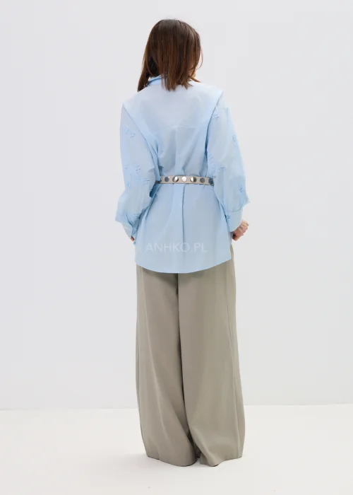 Koszula oversize błękitna z haftem kwiatowym, zapinana na guziki, z długim rękawem i klasycznym kołnierzem – elegancko-casualowa stylizacja z paskiem w talii.