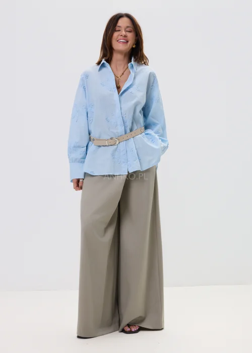Koszula oversize błękitna z haftem kwiatowym, zapinana na guziki, z długim rękawem i klasycznym kołnierzem – elegancko-casualowa stylizacja z paskiem w talii.