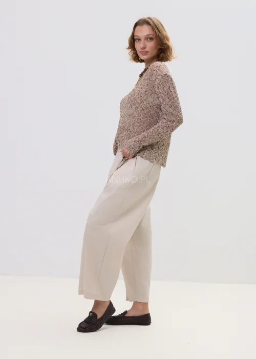 Sweter damski melanżowy w odcieniach beżu i brązu, o luźnym kroju z długim rękawem, zestawiony z jasnymi spodniami – casualowa stylizacja z naturalnym charakterem.
