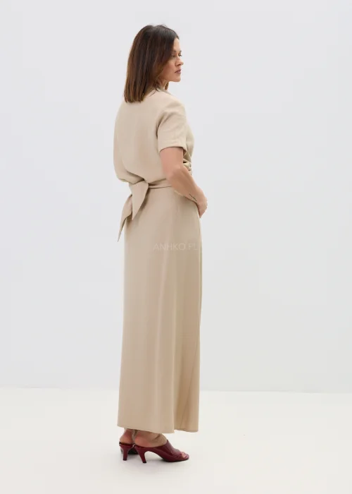 Beżowa bluzka damska z krótkim rękawem i ozdobnym wiązaniem z klamrą, lekka i elegancka.
