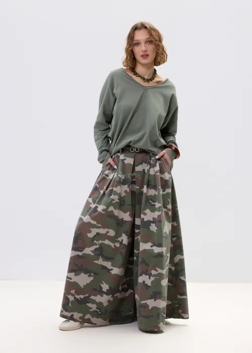 Szerokie spodnie damskie w militarny wzór moro z wysokim stanem i zakładkami w pasie, w stylizacji z paskiem i sneakersami.
