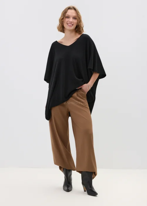 Czarny sweter damski z dodatkiem kaszmiru o luźnym, oversize’owym kroju z szerokimi rękawami i dekoltem w serek, w stylizacji z eleganckimi spodniami.