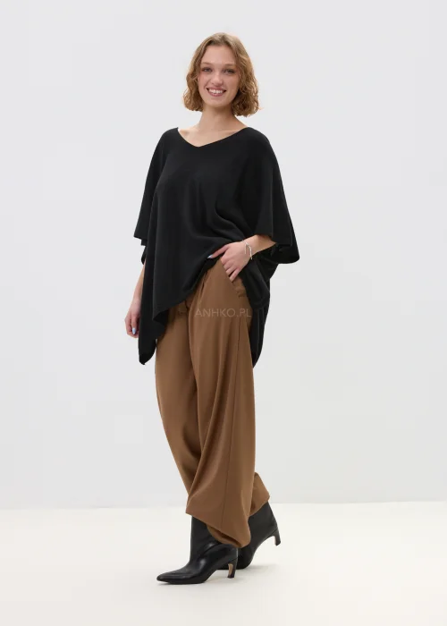 Camelowe spodnie damskie z szeroką nogawką o eleganckim kroju, gładki materiał, stylizowane z dopasowanym topem w minimalistycznym looku.