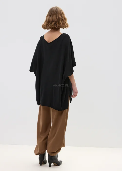 Camelowe spodnie damskie z szeroką nogawką o eleganckim kroju, gładki materiał, stylizowane z dopasowanym topem w minimalistycznym looku.