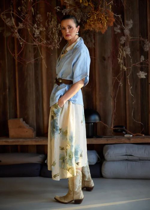 Lniana marynarka damska w kolorze baby blue o luźnym kroju, z krótkim rękawem i klasycznym kołnierzem, stylizacja warstwowa w naturalnym, eleganckim klimacie.