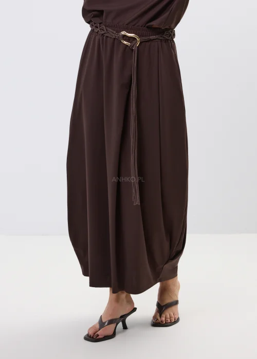 Brązowa spódnica maxi z elastyczną talią i ozdobnym paskiem. Lekko drapowany fason pięknie układa się w ruchu i dodaje stylizacji nowoczesnej elegancji.