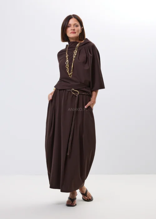 Brązowa spódnica maxi z elastyczną talią i ozdobnym paskiem. Lekko drapowany fason pięknie układa się w ruchu i dodaje stylizacji nowoczesnej elegancji.
