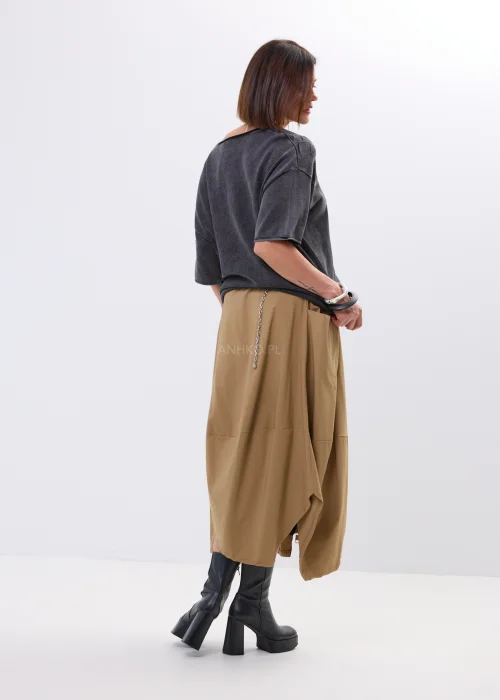 Spódnica midi w karmelowym odcieniu o asymetrycznym, lekko oversize’owym fasonie. Model z efektownymi przeszyciami i dużą kieszenią po boku nadaje stylizacji nowoczesnego charakteru i swobodnego ruchu.