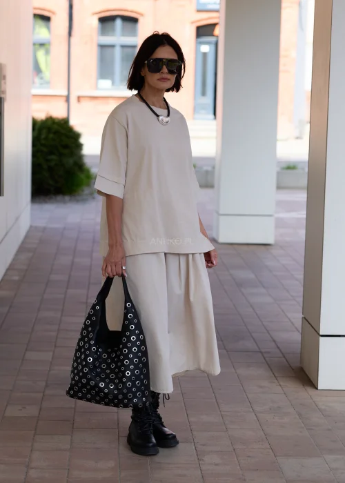 Czarna torba damska z kosmetyczką i ozdobnymi metalowymi oczkami w nowoczesnym stylu urban chic. Miękki model shopper z efektownymi detalami, idealny do codziennych stylizacji.