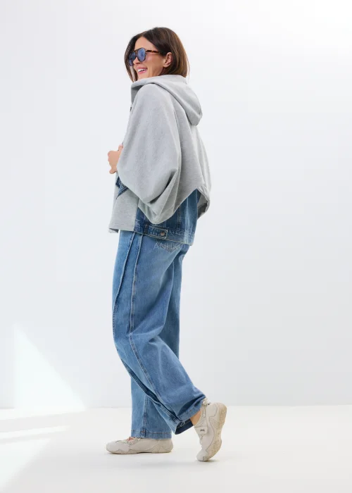 Szara bluza oversize z kapturem i jeansowymi kieszeniami. Luźny fason oraz surowe denimowe detale nadają całości casualowego, miejskiego charakteru.