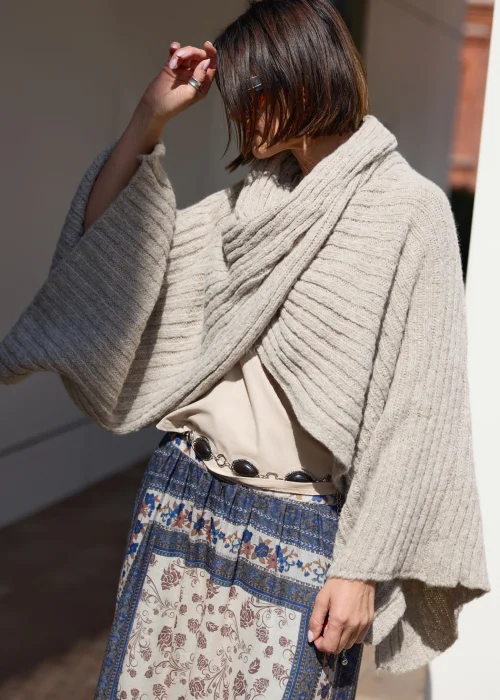 Beżowe sweter-ponczo w odcieniu taupe o miękkim, otulającym splocie i oversize’owym fasonie. Ciepły model z szerokim kołnierzem, idealny do warstwowych stylizacji w stylu boho i casual chic.
