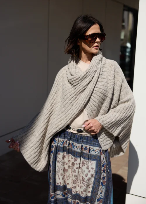 Beżowe sweter-ponczo w odcieniu taupe o miękkim, otulającym splocie i oversize’owym fasonie. Ciepły model z szerokim kołnierzem, idealny do warstwowych stylizacji w stylu boho i casual chic.