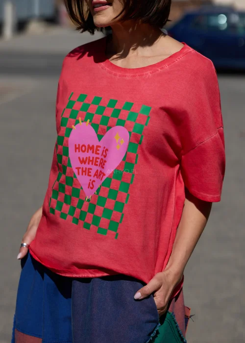 Damski t-shirt oversize w kolorze malinowym z kolorowym nadrukiem i napisem „Home is where the art is” w casualowej stylizacji.