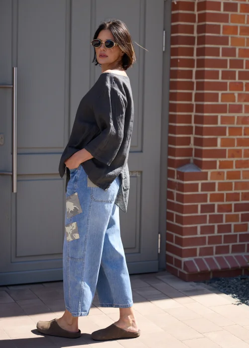 Jeansowe spodnie wide leg z naszywkami moro i luźnym fasonem w miejskiej casualowej stylizacji.
