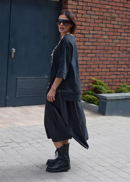 Czarna sukienka oversize midi z szerokim rękawem i minimalistycznym fasonem w nowoczesnej miejskiej stylizacji.