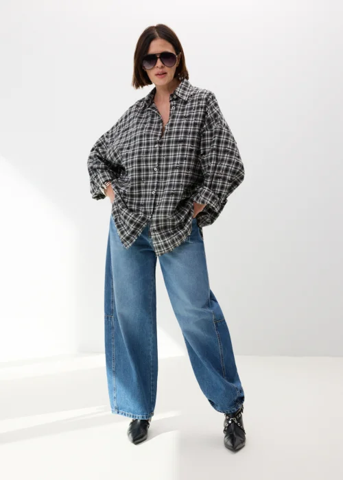 Oversize’owa koszula damska w czarno-białą kratę z efektem delikatnych przetarć i surowym wykończeniem. Luźny fason w stylu grunge świetnie komponuje się z jeansami wide leg i miejskimi stylizacjami casual.