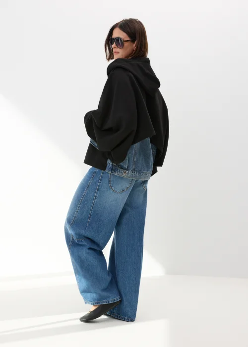 Czarna bluza damska oversize z kapturem i jeansowymi kieszeniami na suwak w nowoczesnym streetwearowym stylu.
