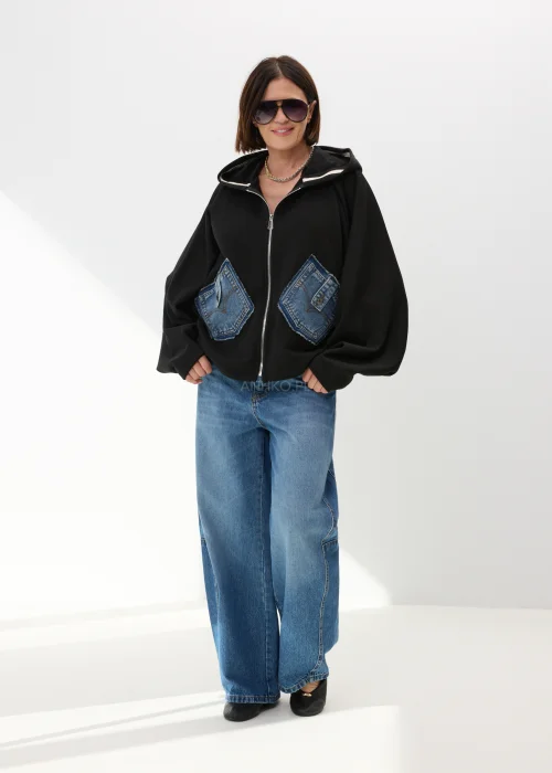 Czarna bluza damska oversize z kapturem i jeansowymi kieszeniami na suwak w nowoczesnym streetwearowym stylu.