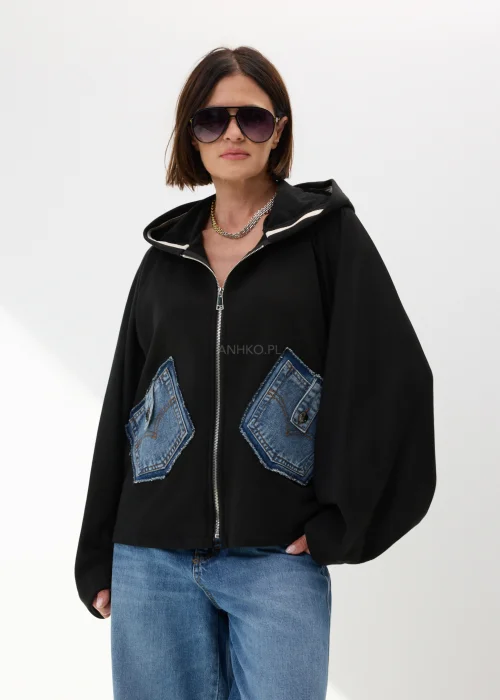 Czarna bluza damska oversize z kapturem i jeansowymi kieszeniami na suwak w nowoczesnym streetwearowym stylu.