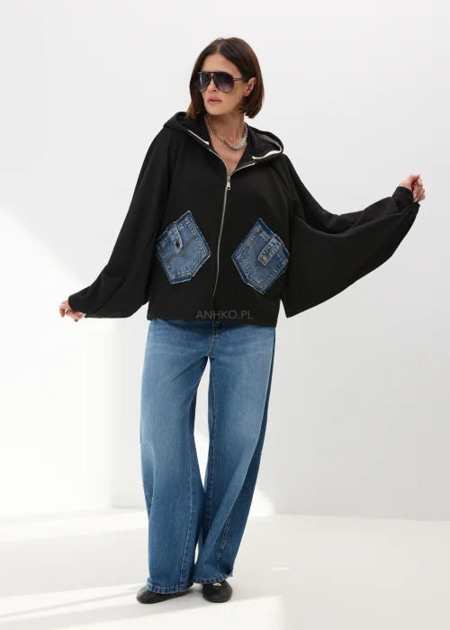 Czarna bluza damska oversize z kapturem i jeansowymi kieszeniami na suwak w nowoczesnym streetwearowym stylu.