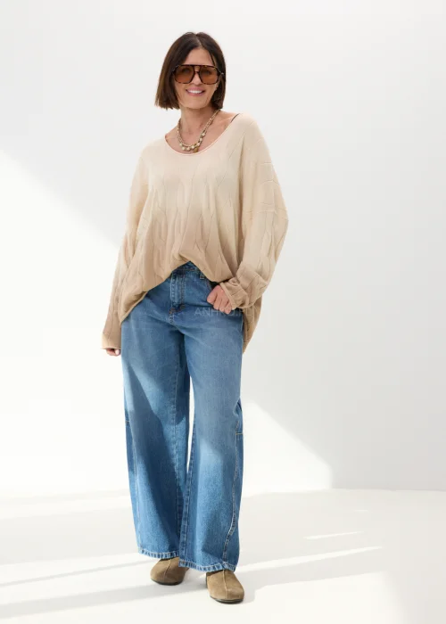 Beżowy sweter oversize o luźnym kroju z delikatnym tłoczonym wzorem i szerokim dekoltem. Miękki model idealny do codziennych stylizacji z jeansami lub spodniami wide leg.