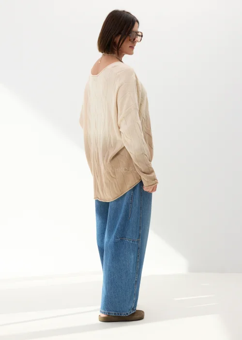 Beżowy sweter oversize o luźnym kroju z delikatnym tłoczonym wzorem i szerokim dekoltem. Miękki model idealny do codziennych stylizacji z jeansami lub spodniami wide leg.