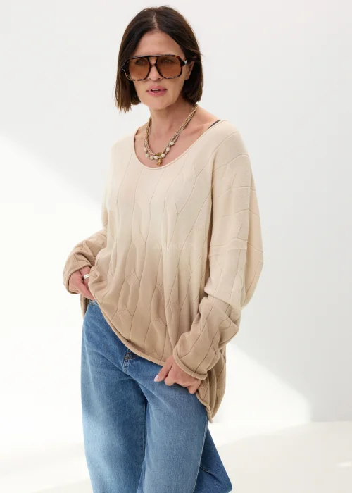 Beżowy sweter oversize o luźnym kroju z delikatnym tłoczonym wzorem i szerokim dekoltem. Miękki model idealny do codziennych stylizacji z jeansami lub spodniami wide leg.