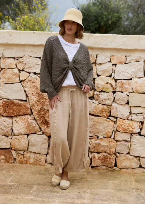 Spodnie lniane safari z luźnym fasonem i ozdobnymi surowymi przeszyciami. Wygodny model z elastycznym pasem i troczkiem, idealny do naturalnych, casualowych stylizacji.