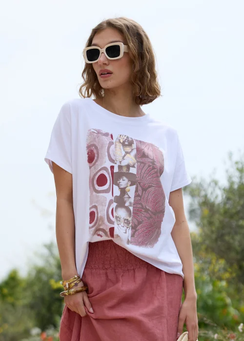 Biały T-shirt damski z artystycznym nadrukiem w odcieniach różu i bordo. Luźny fason z krótkim rękawem, zestawiony z lnianą spódnicą maxi w kolorze przygaszonego różu i naturalnymi dodatkami.