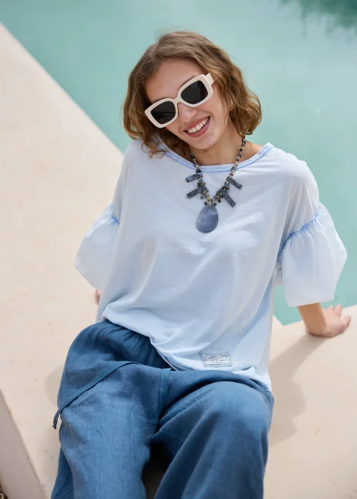 Bluzka oversize w jasnoniebieskim kolorze. Model z efektownymi bufiastymi rękawami i luźnym, swobodnym fasonem.