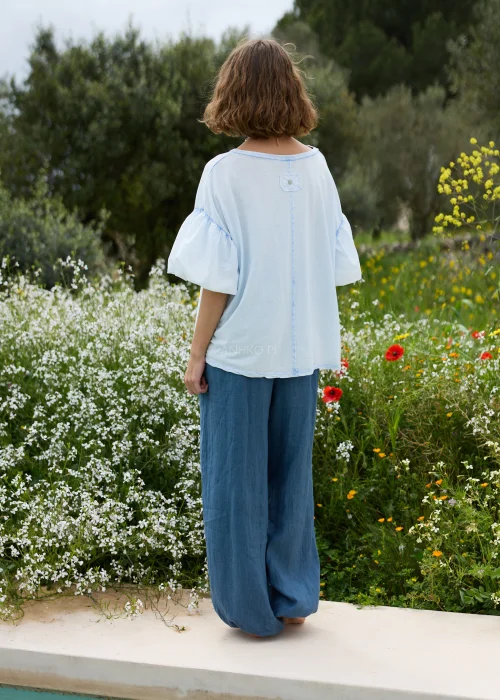 Bluzka oversize w jasnoniebieskim kolorze. Model z efektownymi bufiastymi rękawami i luźnym, swobodnym fasonem.