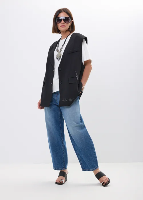 Kamizelka damska oversize w kolorze czarnym z eleganckim kołnierzem i kieszeniami z patkami. Minimalistyczny model bez rękawów świetnie komponuje się z basicowym T-shirtem i jeansami, tworząc nowoczesną miejską stylizację.