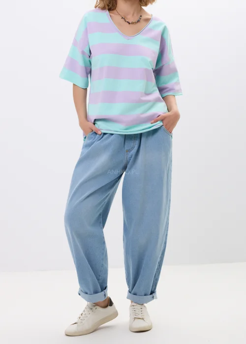 Jasne jeansy damskie o luźnym fasonie baggy z elastyczną gumką w pasie. Model z podwiniętymi nogawkami i miękkim denimem zapewnia wygodę oraz swobodny, miejski charakter stylizacji.