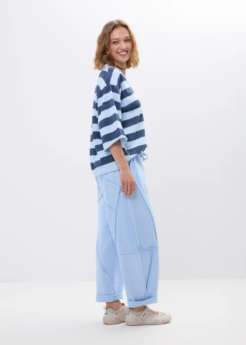Bluzka oversize w niebiesko-granatowe pasy z dekoltem V i rękawem 3/4. Casualowy model w marynistycznym stylu idealny do codziennych stylizacji.