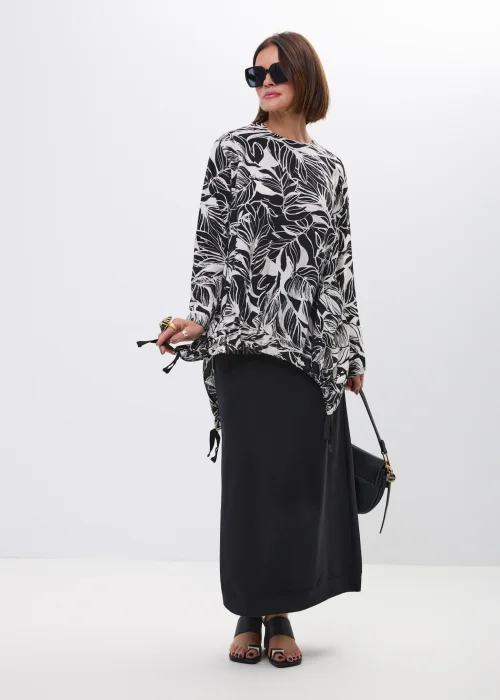 Bluzka-tunika oversize w czarno-biały print liści. Asymetryczny fason z wiązaniami po bokach nadaje stylizacji nowoczesny i artystyczny charakter.