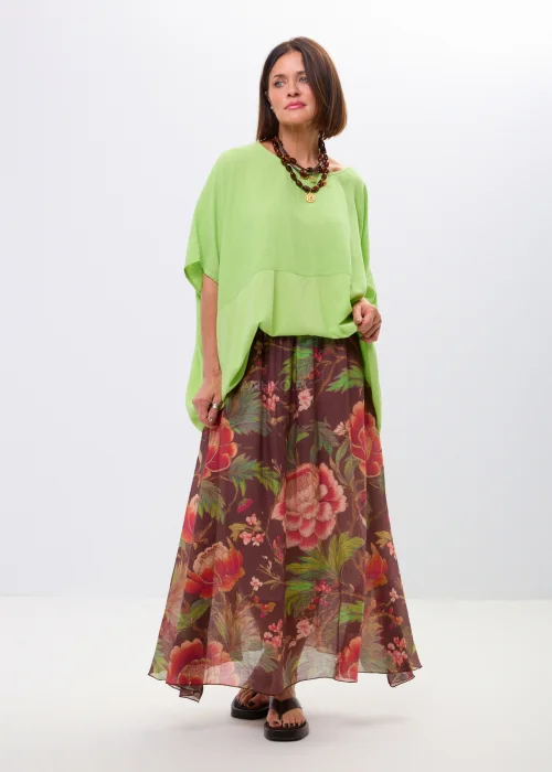 Zwiewna spódnica maxi w kwiatowy wzór na ciemnym tle z dekoracyjnym paskiem i kwiatową aplikacją. Lekka, elegancka spódnica damska z romantycznym printem, idealna do stylizacji boho i casual chic.
