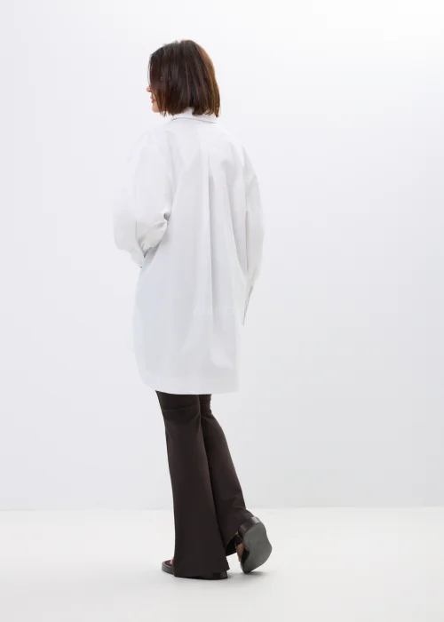 Biała koszula damska oversize z szerokim kołnierzem i efektownymi bufiastymi rękawami. Elegancki, wydłużony fason w minimalistycznym stylu.