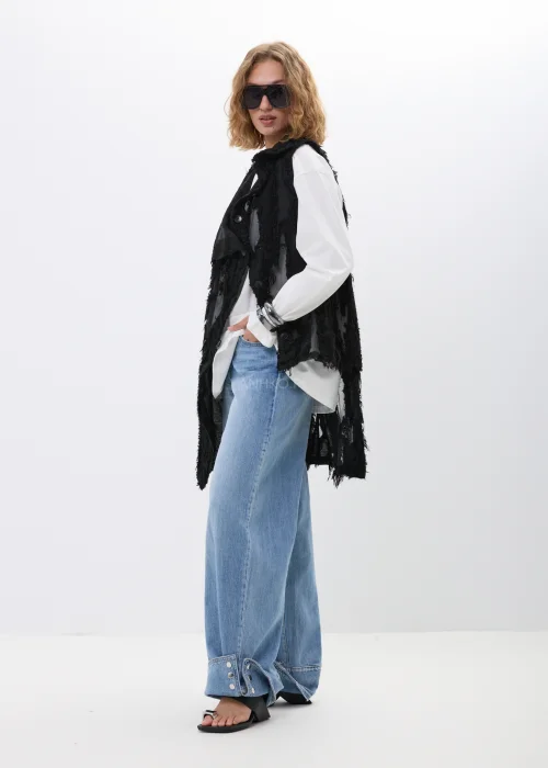 Spodnie jeansowe wide leg w jasnoniebieskim odcieniu z efektownymi mankietami zapinanymi na napy. Szerokie nogawki i nowoczesne detale nadają modelowi modny, swobodny charakter.